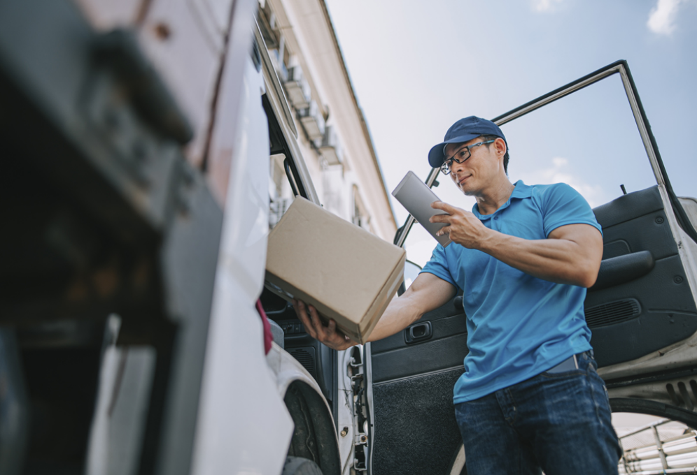 Image of delivery driver scanning a package representing shipping management services.